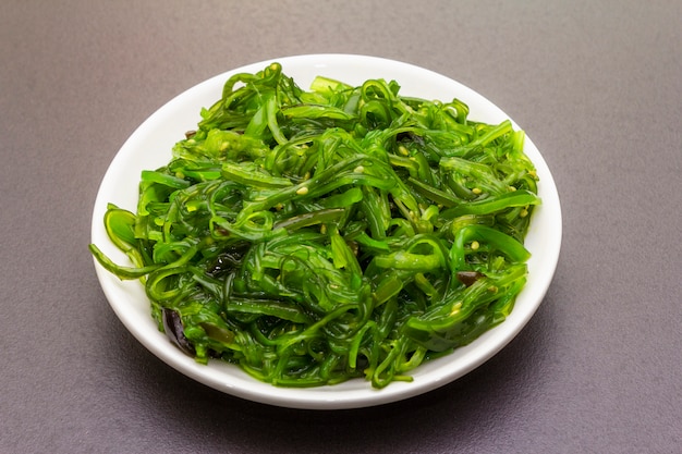 Foto ensalada tradicional japonesa de algas hiyashi wakame chuka con semillas de sésamo.