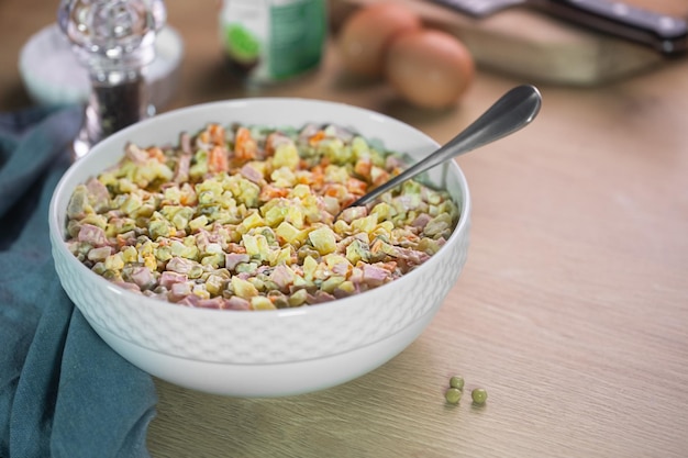 Ensalada tradicional rusa Olivier con guisantes en la mesa de la cocina