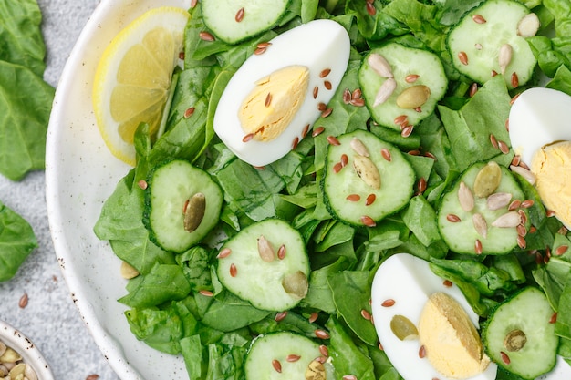 Ensalada útil de espinacas, pepinos, huevos y semillas (calabaza, lino y girasol)