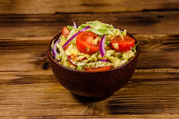 Ensalada vegana con col rizada, tomates y cebolla en un bol de cerámica