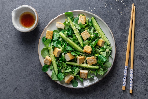 Ensalada vegana con pepino tofu y sésamo servido en plato Primer plano