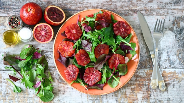 Ensalada vegana saludable mezcla con naranjas rojas.