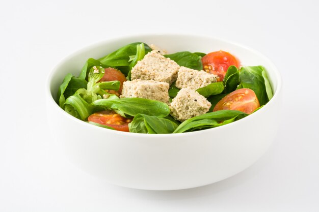 Ensalada vegana de tofu con tomate y lechuga de cordero en blanco