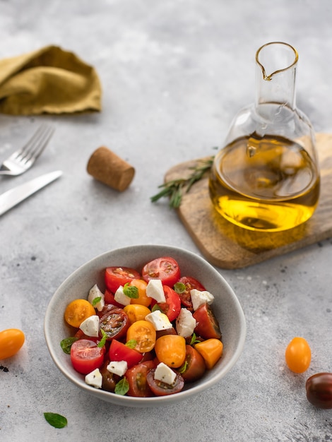 Ensalada de vegetales frescos con queso feta en un tazón Dieta de comida sana superficie de concreto gris,