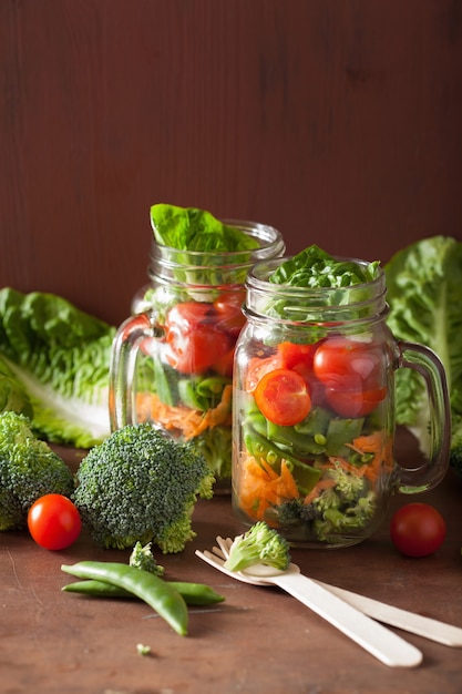 Ensalada de vegetales saludables en tarro de masón. tomate brócoli zanahoria guisante