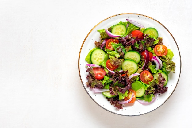 Ensalada de vegetales saludables de tomates cherry rojos, rodajas de pepino y lechuga