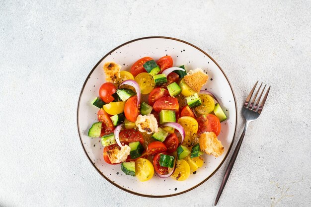 Ensalada vegetariana Panzanella con tomate cebolla y pan Crutones Fondo claro Vista superior Ensalada italiana