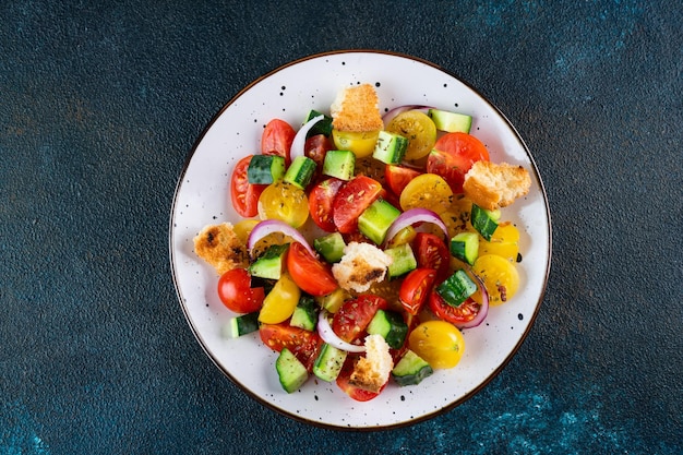 Ensalada vegetariana Panzanella con tomate cebolla y pan Crutones Fondo oscuro Vista superior Ensalada italiana