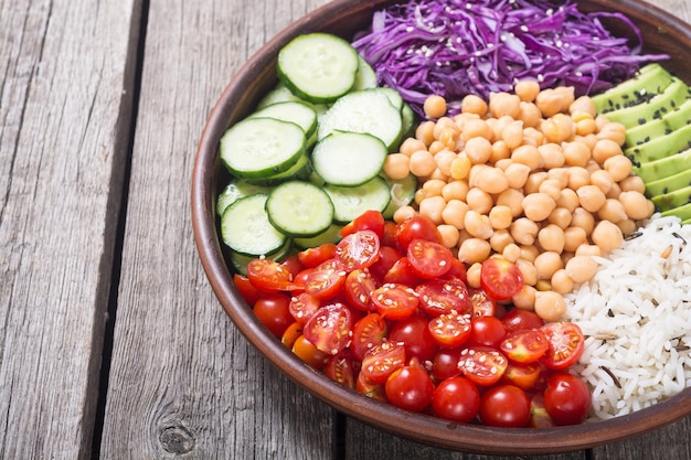 Ensalada vegetariana saludable con aguacate, pepino, col, garbanzos y tomates, comida vegana