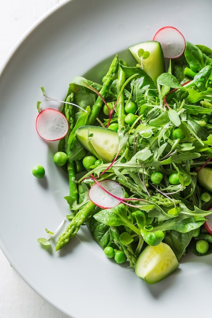 Ensalada vegetariana saludable con espinacas, rábanos y espárragos