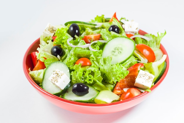 Ensalada vegetariana con tomate, queso, lechuga y otros ingredientes. Ensalada de verduras en el bol.