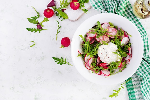 Ensalada vegetariana de verduras de rábano y rúcula con crema agria