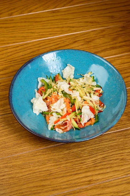 Ensalada vegetariana de verduras con tomates, pimientos y cebollas en la mesa de madera ensalada saludable con verduras frescas maduras de verano