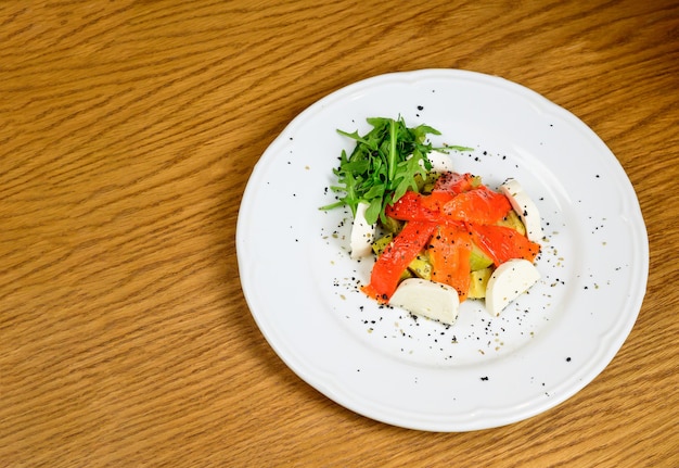 Ensalada vegetariana de verduras con tomates, pimientos y cebollas en la mesa de madera ensalada saludable con verduras frescas maduras de verano