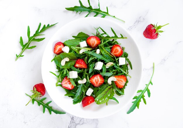 Ensalada de verano de fresa con rúcula, hojas de espinaca, queso feta y anacardos