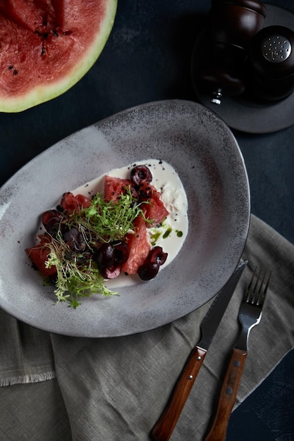 Ensalada de verano hecha de sandía, queso strachatella, hojas de menta fresca y micro verduras Vista superior con espacio para copiar