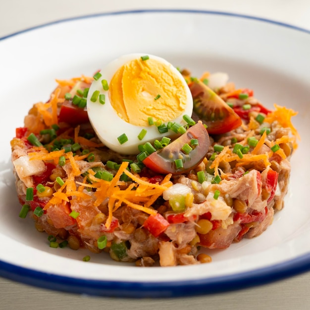 Ensalada de verano con lentejas, verduras y huevo hervido.