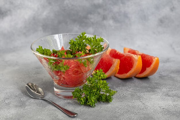 Ensalada de verano con pomelo sobre un fondo claro con hierbas. Aislar. Copie el espacio.