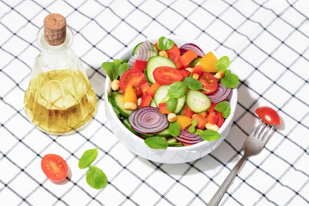 Ensalada de verano con tomates cherry, pepino, pimiento, cebolla, albahaca y maní