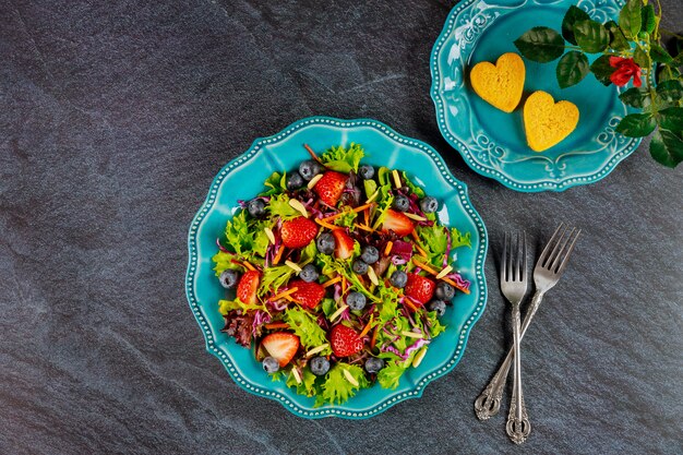 Ensalada verde con bayas y nuggets de pollo y rosa Concepto de día de San Valentín.