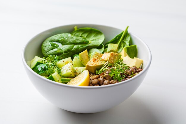 Ensalada verde con espinacas, lentejas, aguacate y pepino.