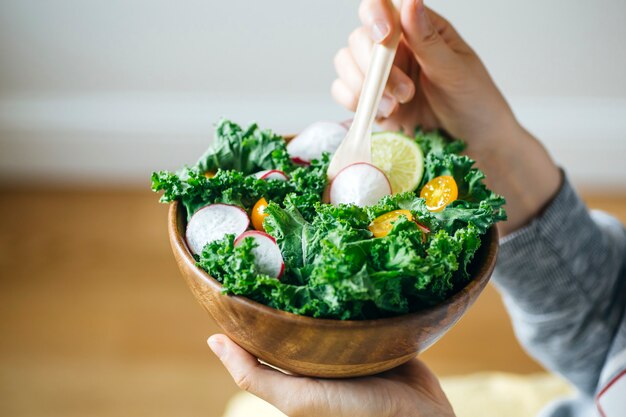 Ensalada verde fresca en un tazón de madera.