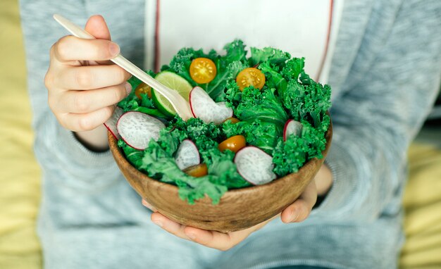 Ensalada verde fresca en un tazón de madera.