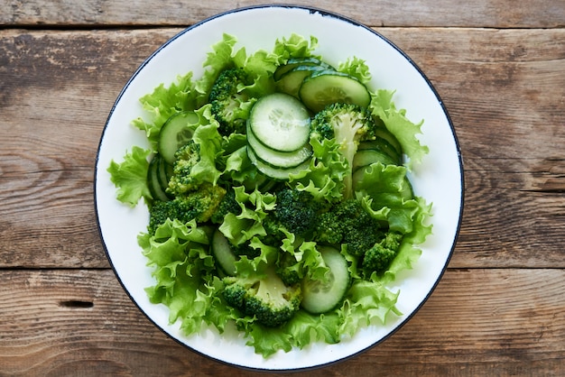 Ensalada de verduras con brócoli, pepinos y lechuga en un tazón blanco