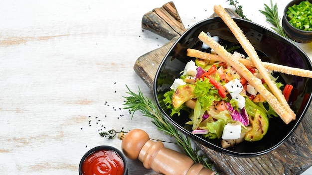 Ensalada de verduras con calabacín de pollo y queso feta en un plato negro Vista superior Espacio libre para el texto