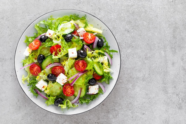 Ensalada con verduras crudas frescas pepino tomate cebolla lechuga y queso feta cocina griega comida saludable vista superiorxA