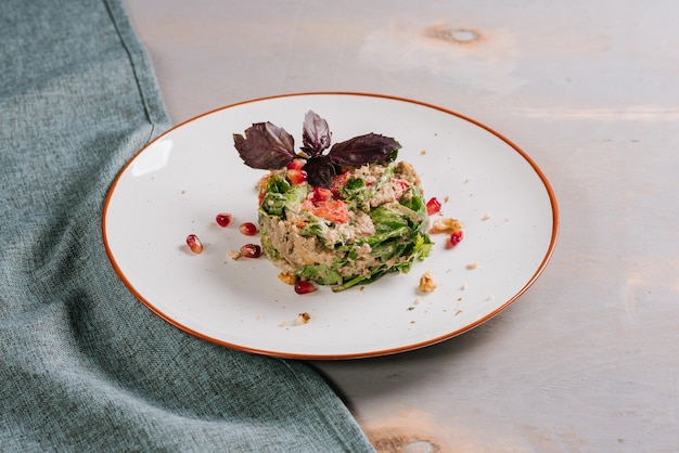 Ensalada de verduras con especias en forma redondeada sobre el fondo de madera