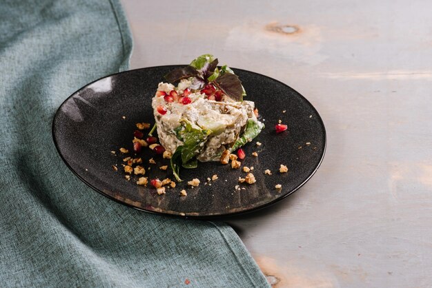 Ensalada de verduras con especias en forma redondeada sobre el fondo de madera