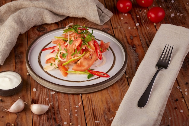 Ensalada de verduras frescas con aceite, fondo de madera