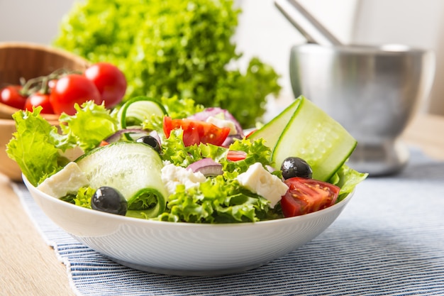 Ensalada con verduras frescas aceitunas tomates cebolla morada queso griego feta y aceite de oliva.