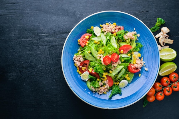 Ensalada con verduras frescas y atún Sobre un fondo de madera Vista superior Espacio libre para el texto