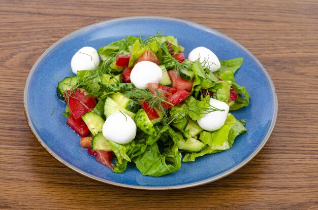 Ensalada de verduras frescas con bolas de mozzarella.