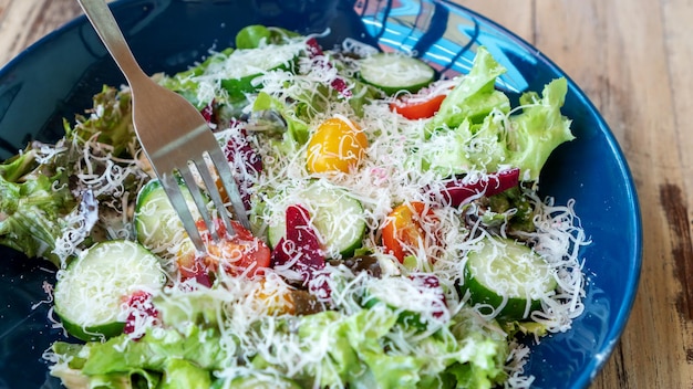 Ensalada de verduras frescas con queso en una mesa de madera