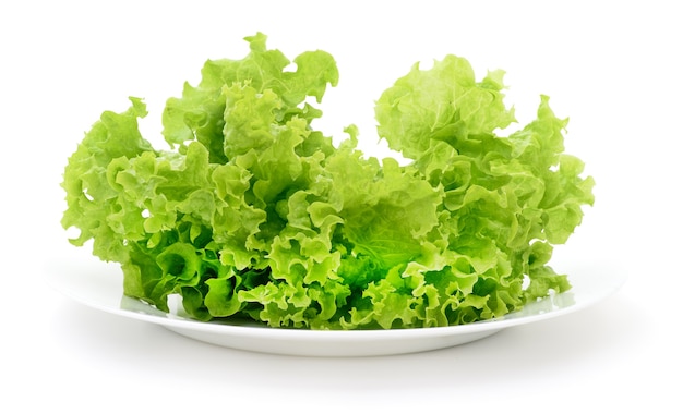 Ensalada de verduras frescas en un tazón de vidrio aislado sobre fondo blanco.