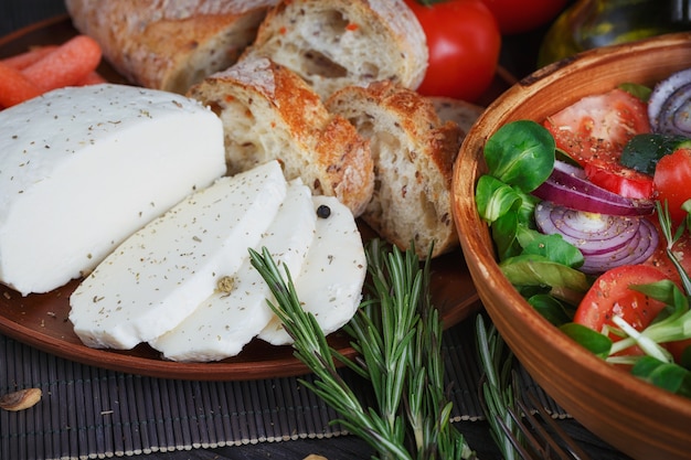 Ensalada de verduras frescas con tomates, pepinos y cebollas. Servido con queso, verduras, aceite de oliva y pan.