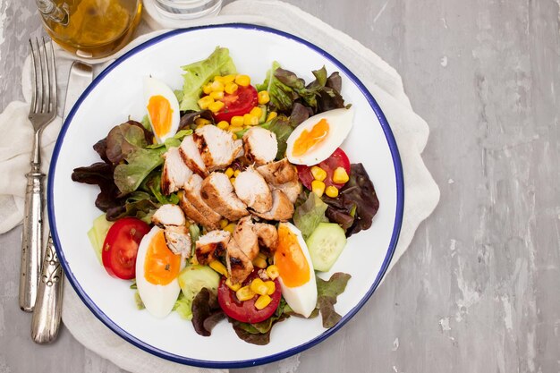 ensalada de verduras hecha de tomates conservas de maíz pepino lechuga aguacate huevo y pollo