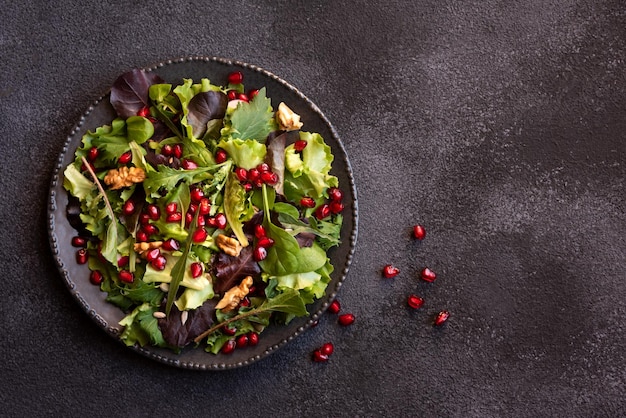 Ensalada de verduras con hojas verdes y semillas de granada