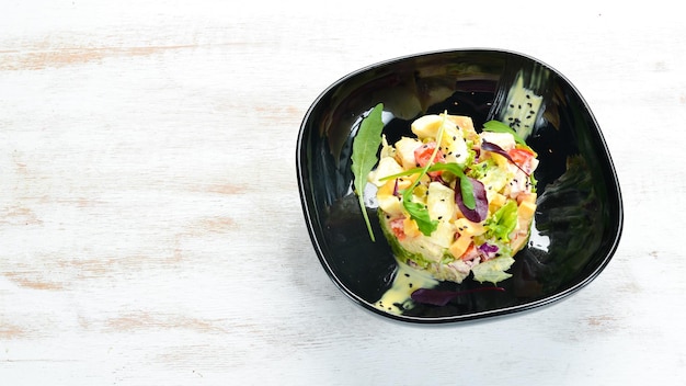 Ensalada de verduras con huevo de pollo y salsa de mayonesa en un plato negro Vista superior Espacio libre para el texto