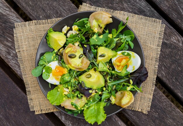 Ensalada con verduras, huevos y verduras en la mesa de madera