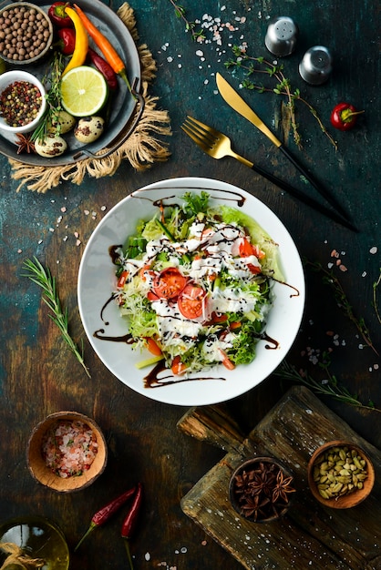 Ensalada de verduras lechuga tomates pepino y salsa de nata César Vista superior Vista superior Estilo rústico