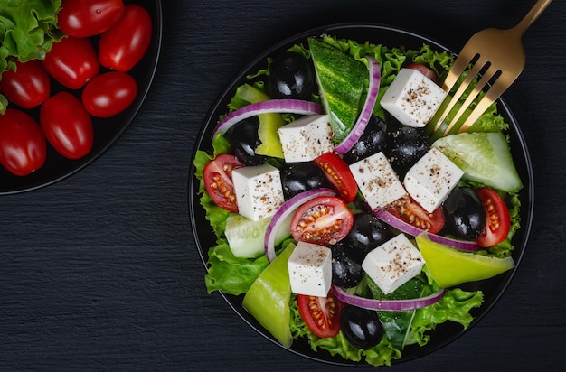 Ensalada de verduras con pepino fresco, tomate, cebolla, lechuga, queso feta, comida saludable, vista superior, espacio de copia