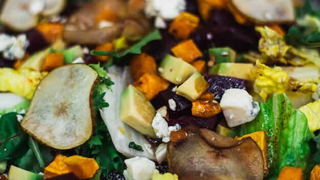 Foto ensalada de verduras de pera caramelizada, remolacha, rúcula, aguacate, zanahoria, con queso dorblu