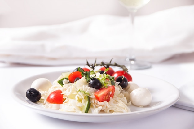 Foto ensalada de verduras en el plato y plato con una variedad de quesos, frutas y otros aperitivos.