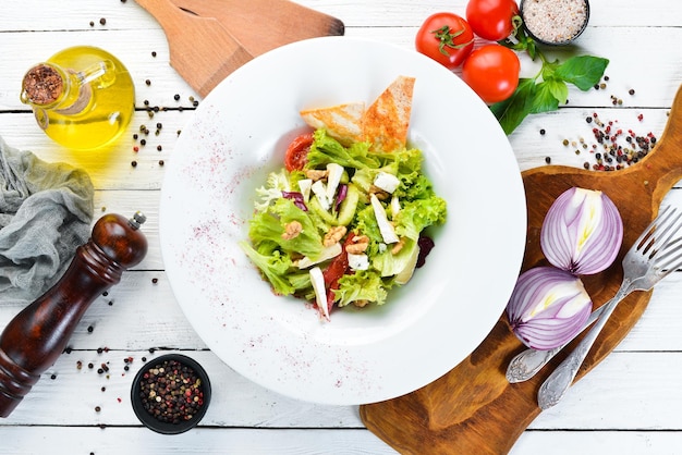 Ensalada de verduras con queso, aceitunas y tomates cherry En el plato Vista superior Espacio libre para su texto Estilo rústico