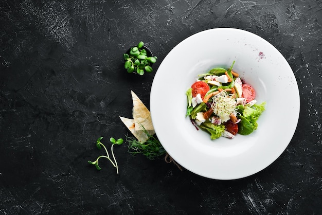 Ensalada de verduras con queso brie, tomates cherry y espinacas En el plato Vista superior Espacio libre para el texto Estilo rústico