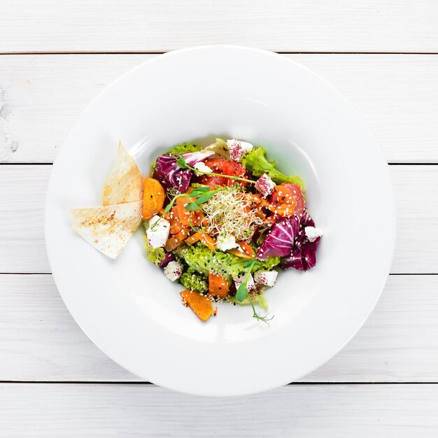 Foto ensalada de verduras con repollo con queso feta en el plato vista superior espacio libre para tu texto estilo rústico